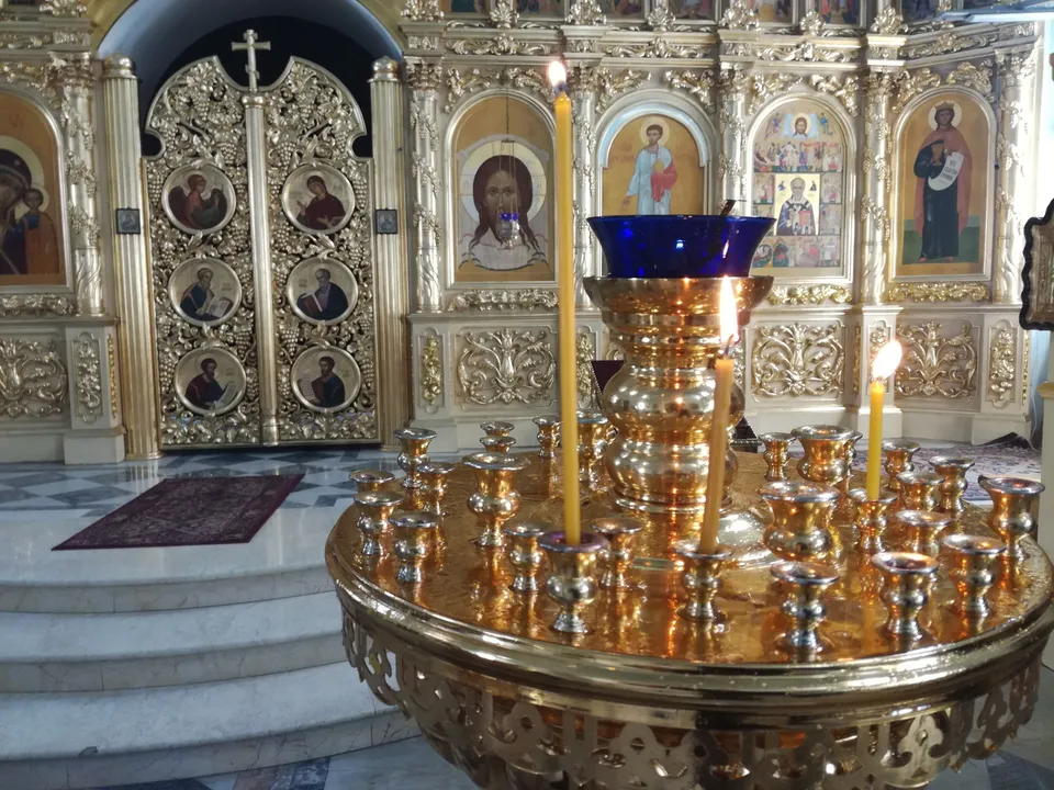 Крыльцо голубого храма с аркой, распахнутой дверью и иконой в киоте над входом
