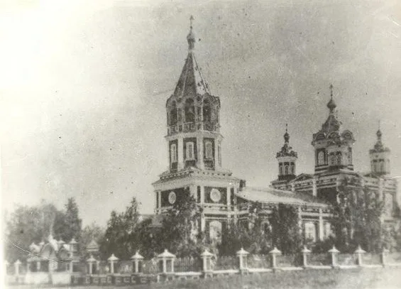 Чёрно-белая дореволюционная фотография храма с пятью главами и колокольней, вокруг — кладбищенские кресты и ограда
